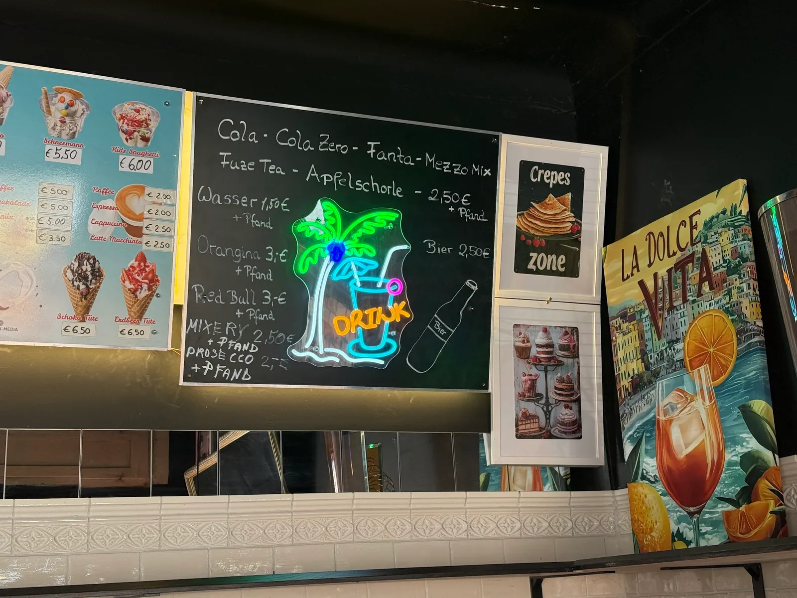 Getränkekarte auf einer Kreidetafel neben einem Neon-Palmenschild
