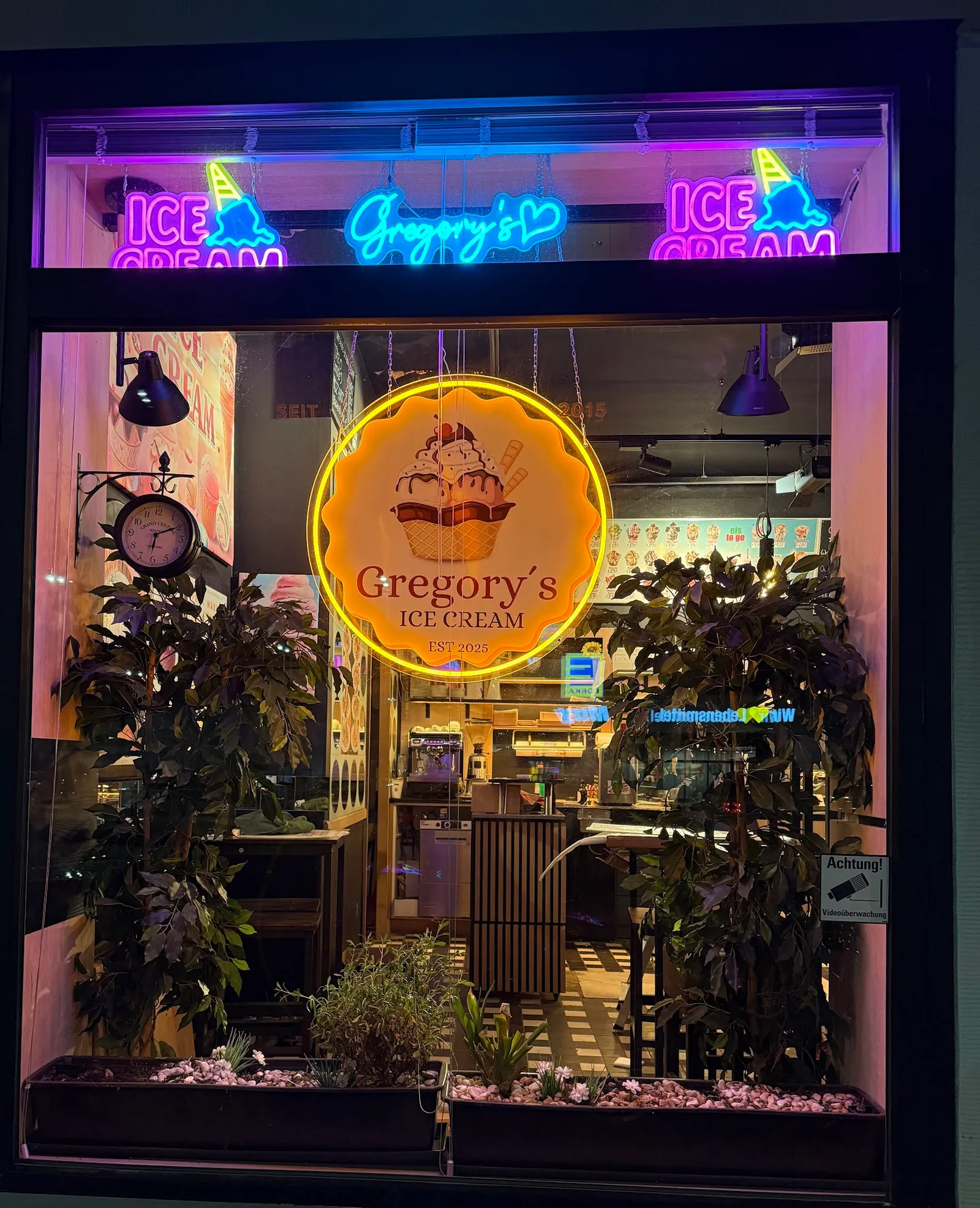 Beleuchtetes Schaufenster von Gregory's Ice Cream bei Nacht mit Neonschild