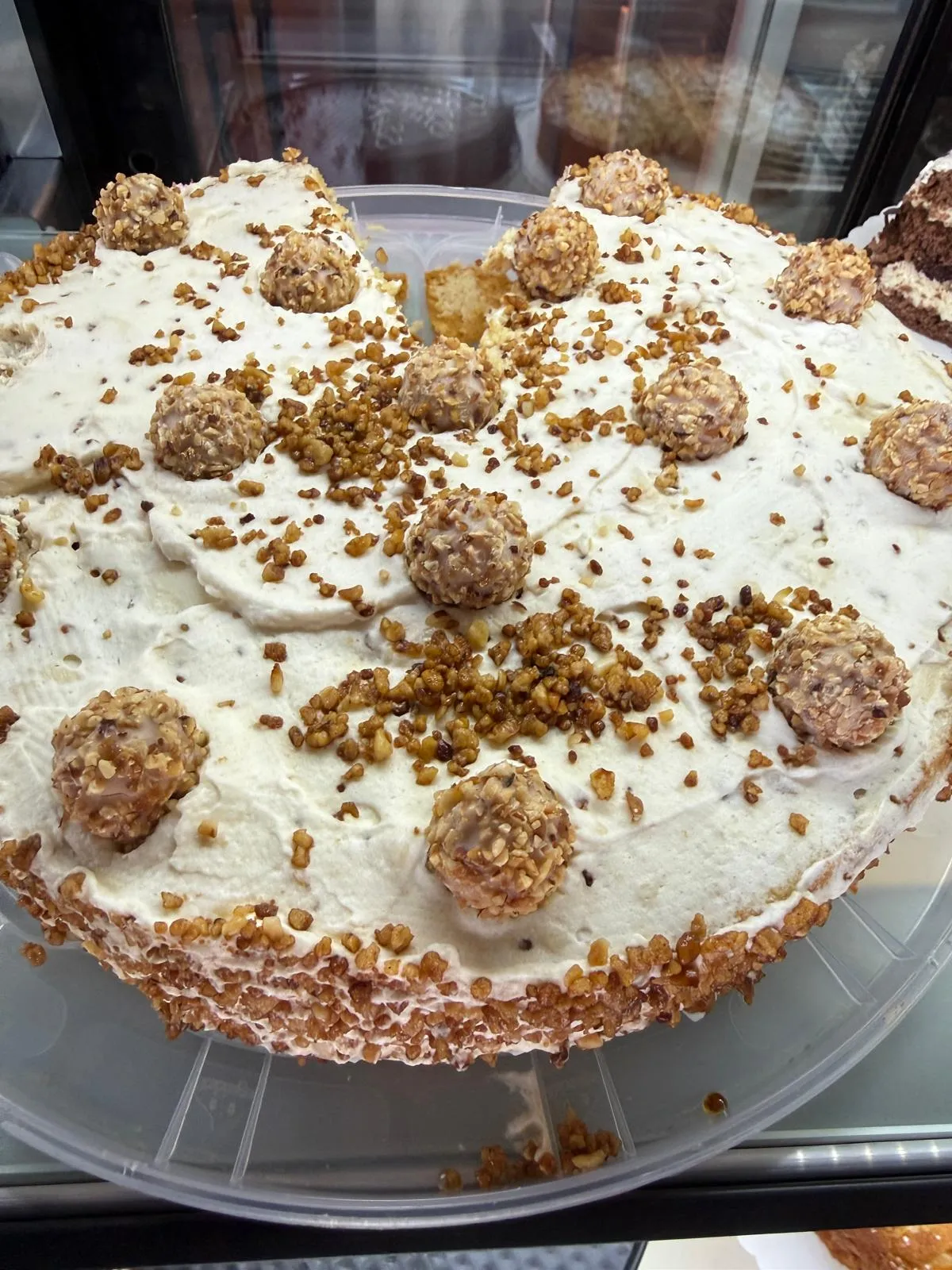 Haselnuss-Sahne-Torte mit gehackten Nüssen und Haselnuss-Pralinen