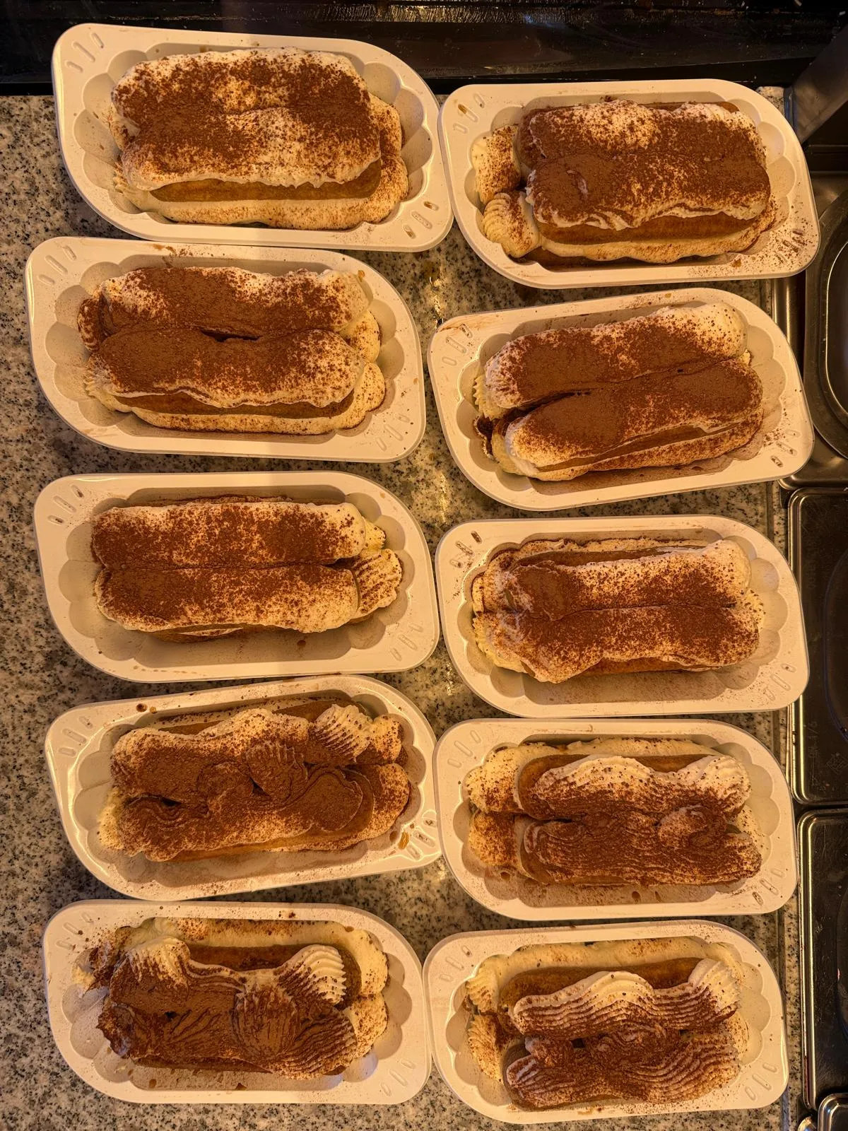 Mehrere frisch zubereitete Tiramisu-Portionen mit Mascarpone und Kakao